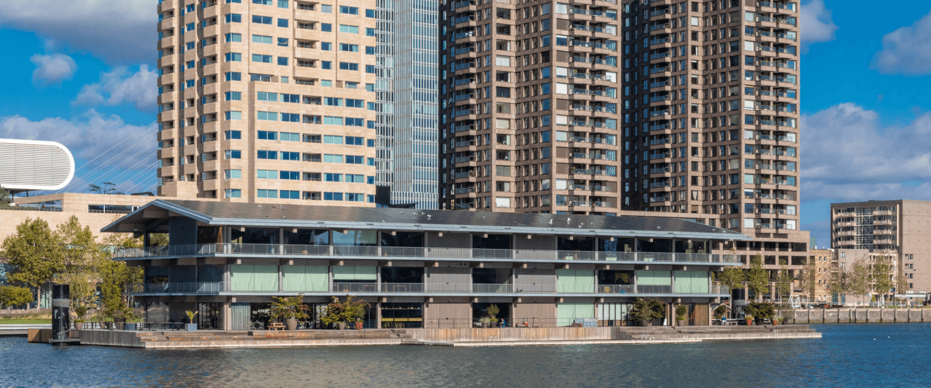 Op de voorgrond Floating Office in Rotterdam en op achtergrond wat kantoor en woontorens