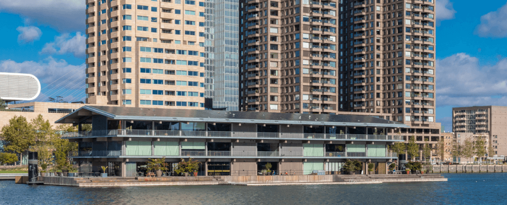 Op de voorgrond Floating Office in Rotterdam en op achtergrond kantoor en woontorens