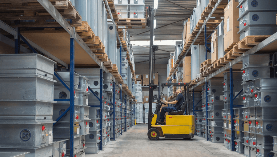 Medewerker Schilt op heftruck in magazijn met TROX producten