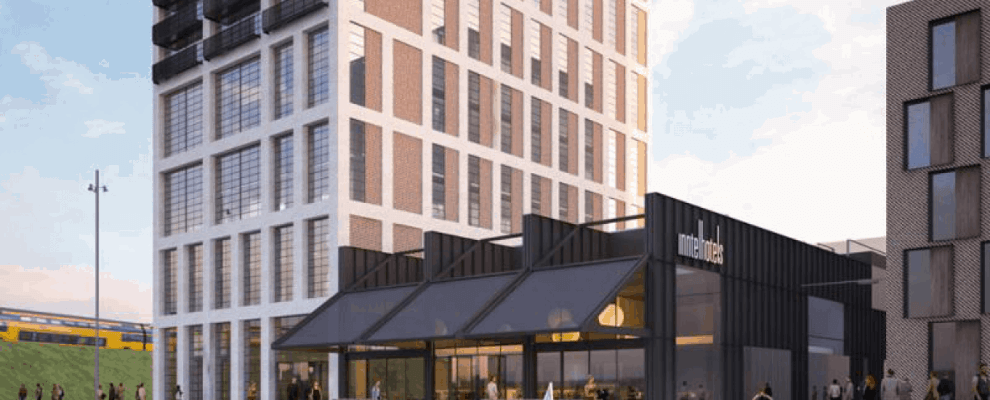 Achterkant gebouw van InntelHotels in Amsterdam met rondvaartboot ervoor