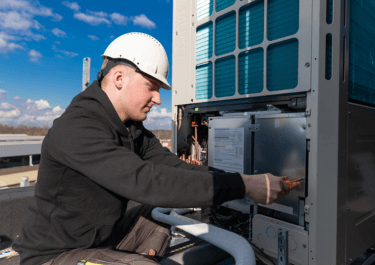 Monteur Schilt airconditioning die op het dak werkzaamheden uitvoert