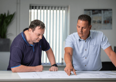 Twee medewerkers op kantoor van Schilt die een tekening bekijken