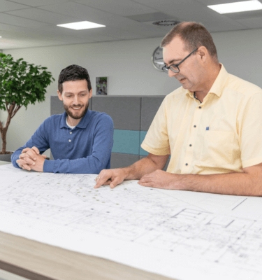 Twee medewerkers op kantoor die een tekening aan het bekijken zijn