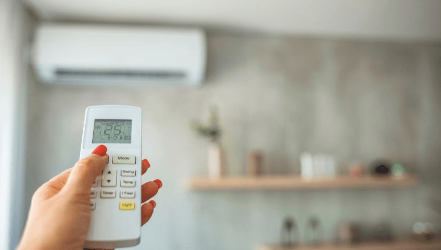 Aircoditioning aan de muur en hand met afstandsbediening