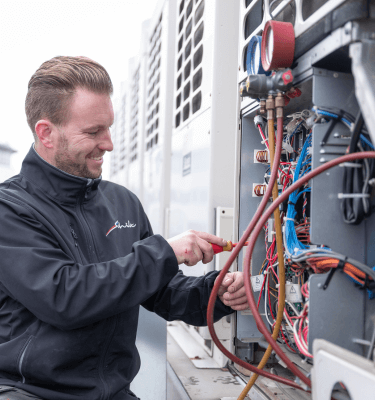 Schilt monteur service en onderhoud die op een dak aan het werk is met een schroevendraaier in zijn hand