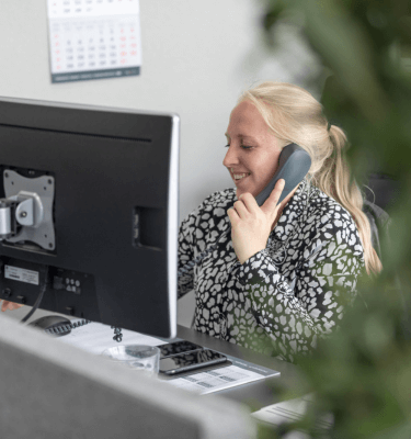 Medewerkster kantoor die aan het bellen is achter haar bureau