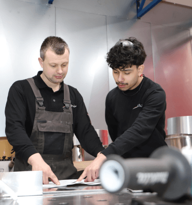 Tweed medewerkers in de werkplaats die een tekening aan het bekijken zijn