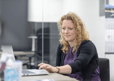 Medewerkster van de financiele administratie met een laptop op het bureau