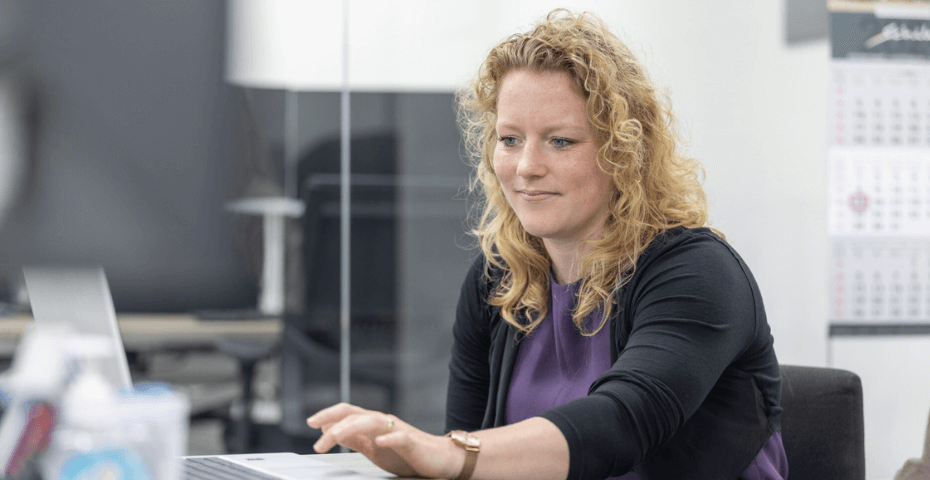 Medewerkster van de financiele administratie met een laptop op het bureau